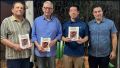 Jo&atilde;o Grandino Rodas, Joaquim Portes de Cerqueira C&eacute;sar e Thomas Law posam com o livro lan&ccedil;ado durante o semin&aacute;rio