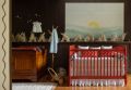 Vista geral do quarto de bebê 'Amanhecer no Campo', destacando o mural pintado à mão e a paleta de cores aconchegante.